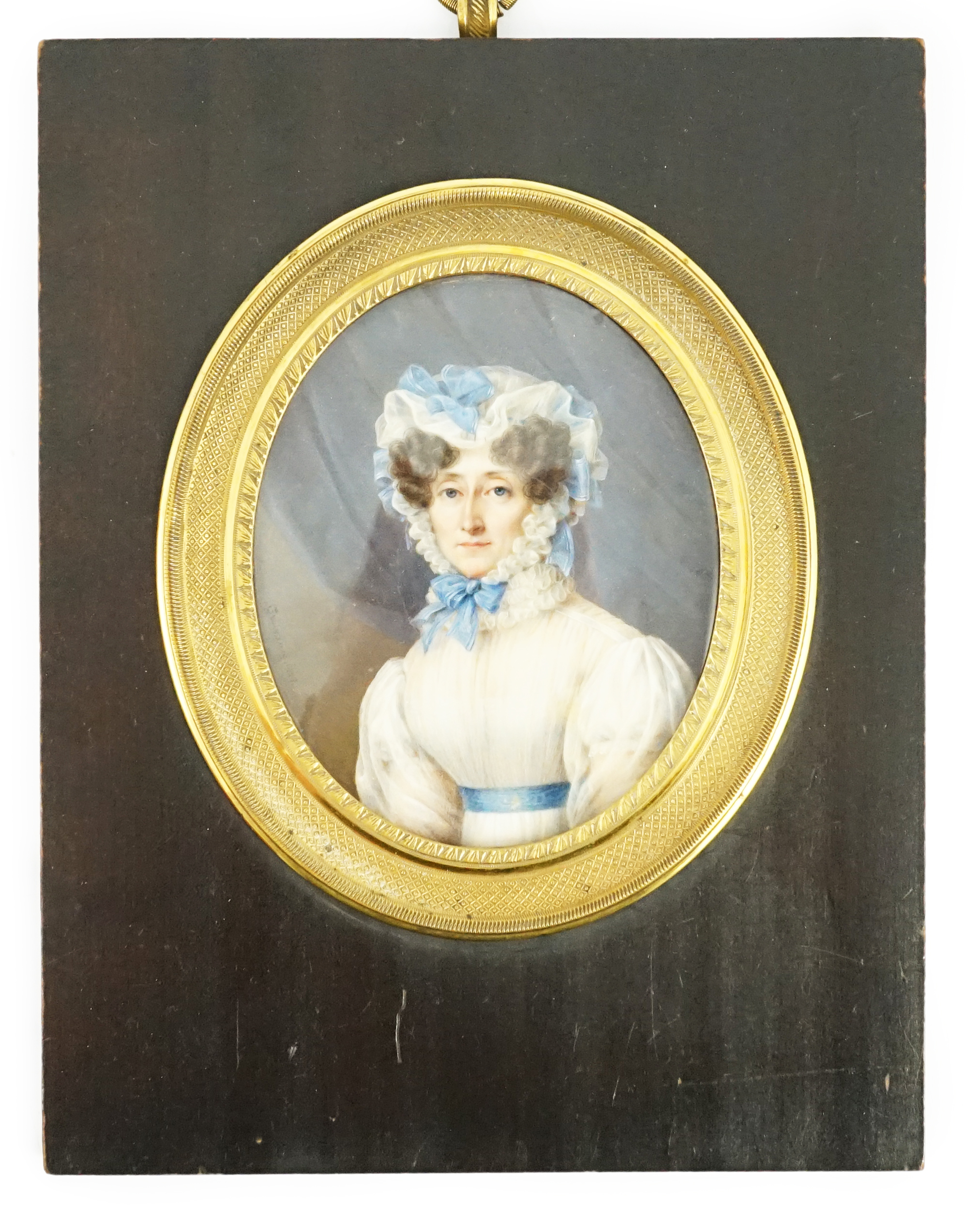 Jean Baptiste Désiré Troivaux (French, 1788-1860), Portrait miniature of a lady, half length, wearing white with a blue sash and blue ribbon-trimmed bonnet, watercolour on ivory, 8.8 x 7.2cm. CITES Submission reference G